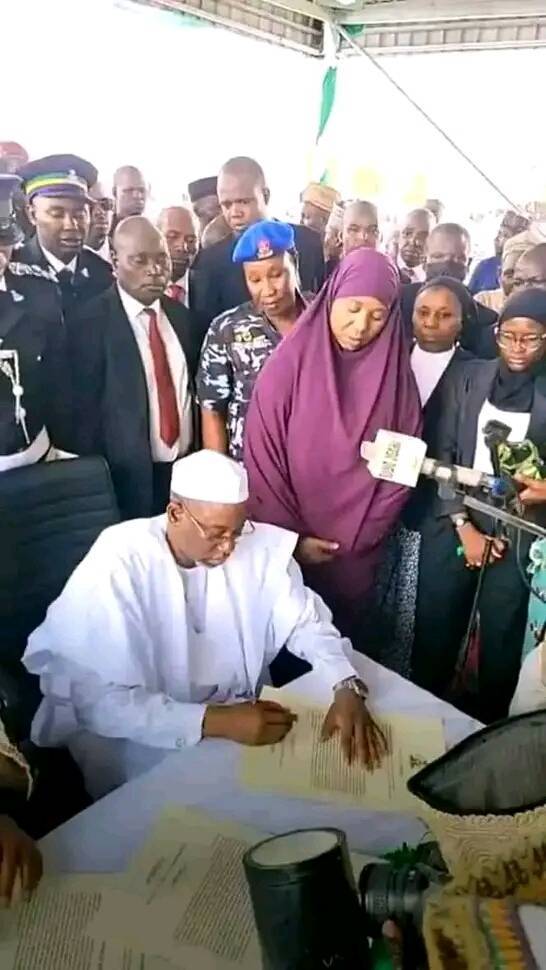 Hajiya Hadiza tana kallon maigidanta, Umar Namadi yayin da yake rattaba hannu bayan rantsuwa